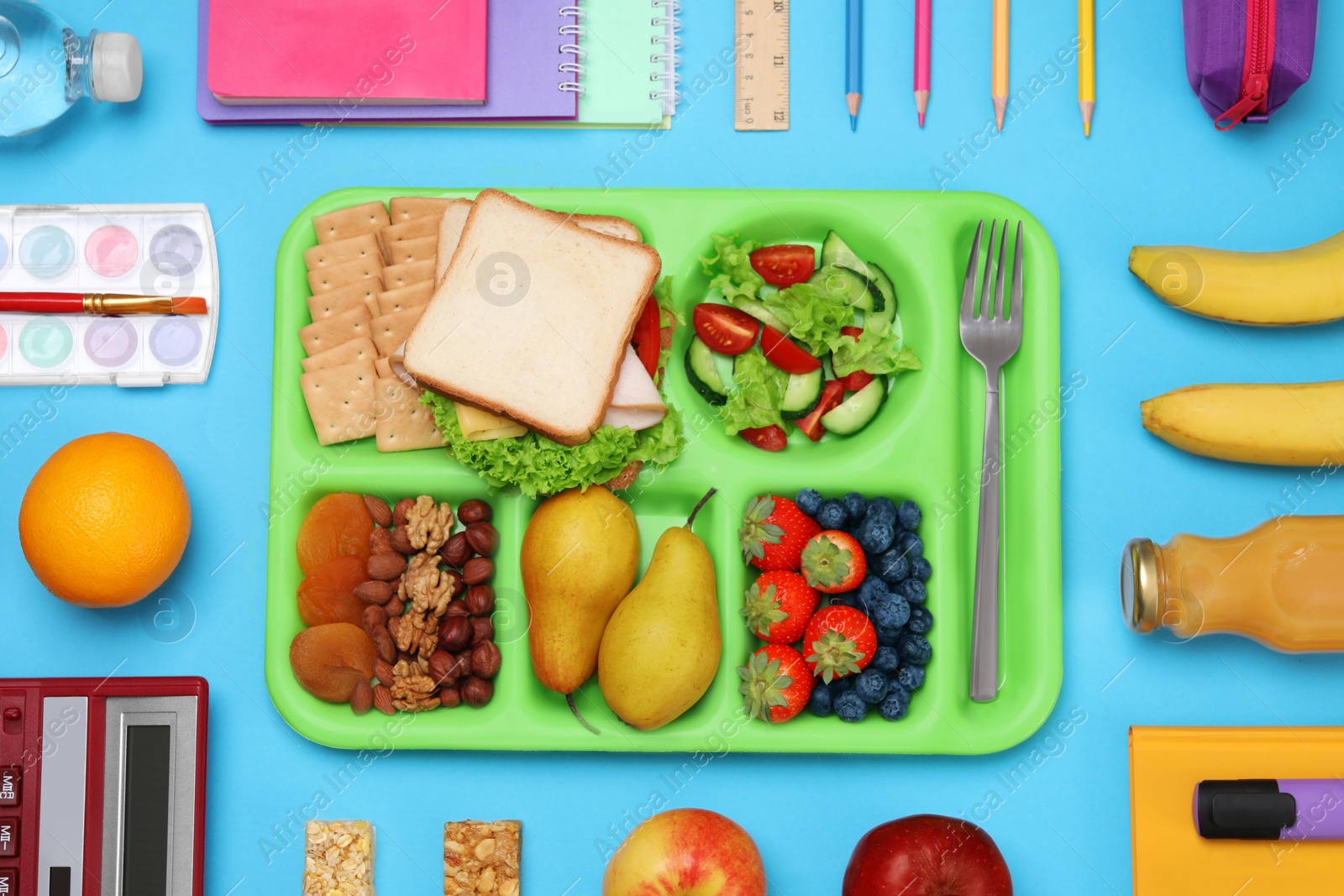 Photo of Flat lay composition with tray, tasty food and school stationery on light blue background