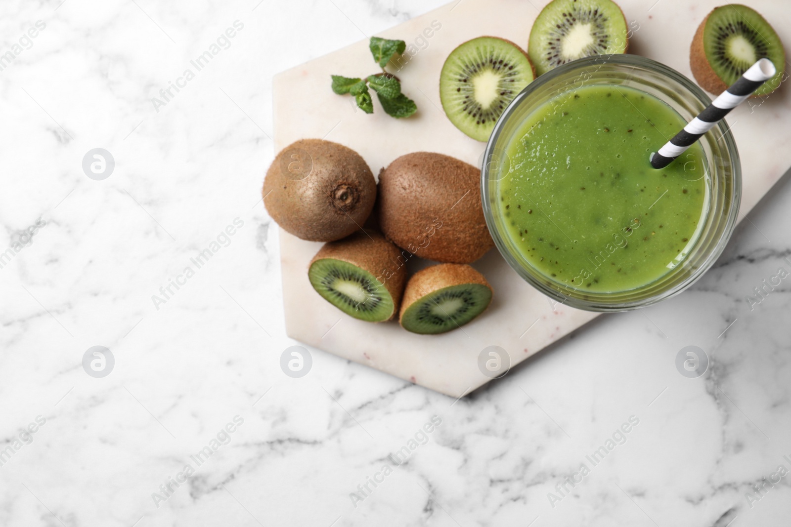 Photo of Delicious kiwi smoothie and fresh fruits on white marble table, top view