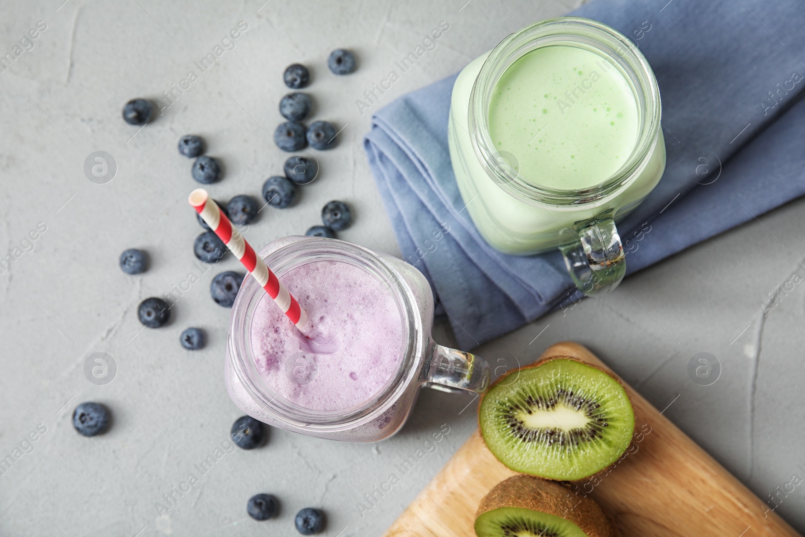 Photo of Flat lay composition with delicious milk shakes on grey background