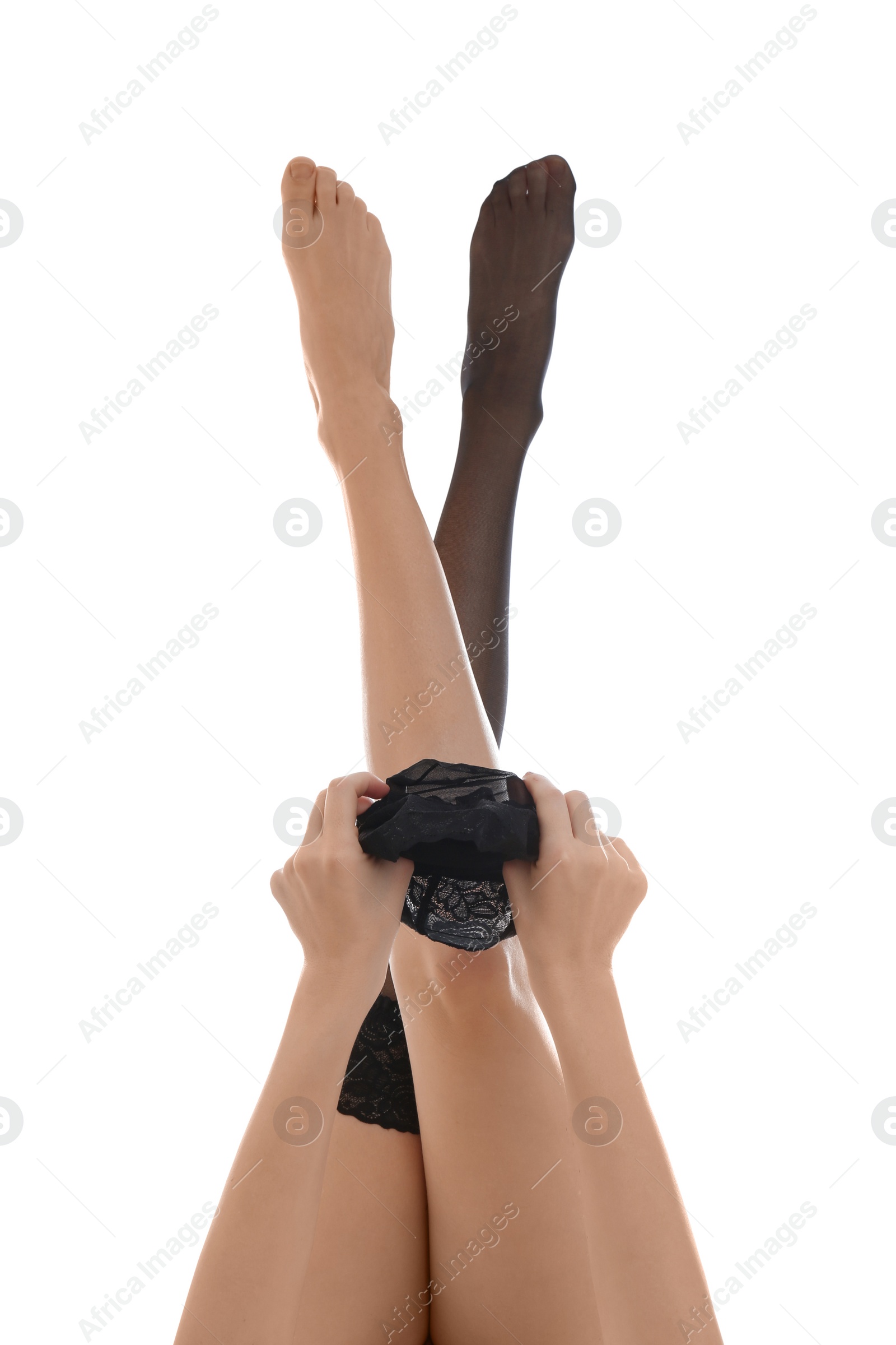 Photo of Young woman putting on stocking against white background, closeup