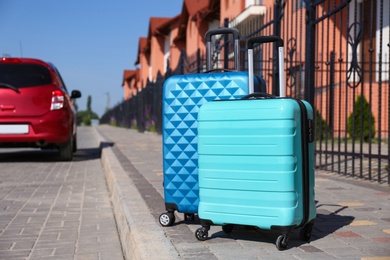 Color suitcases and family car in city. Summer vacation