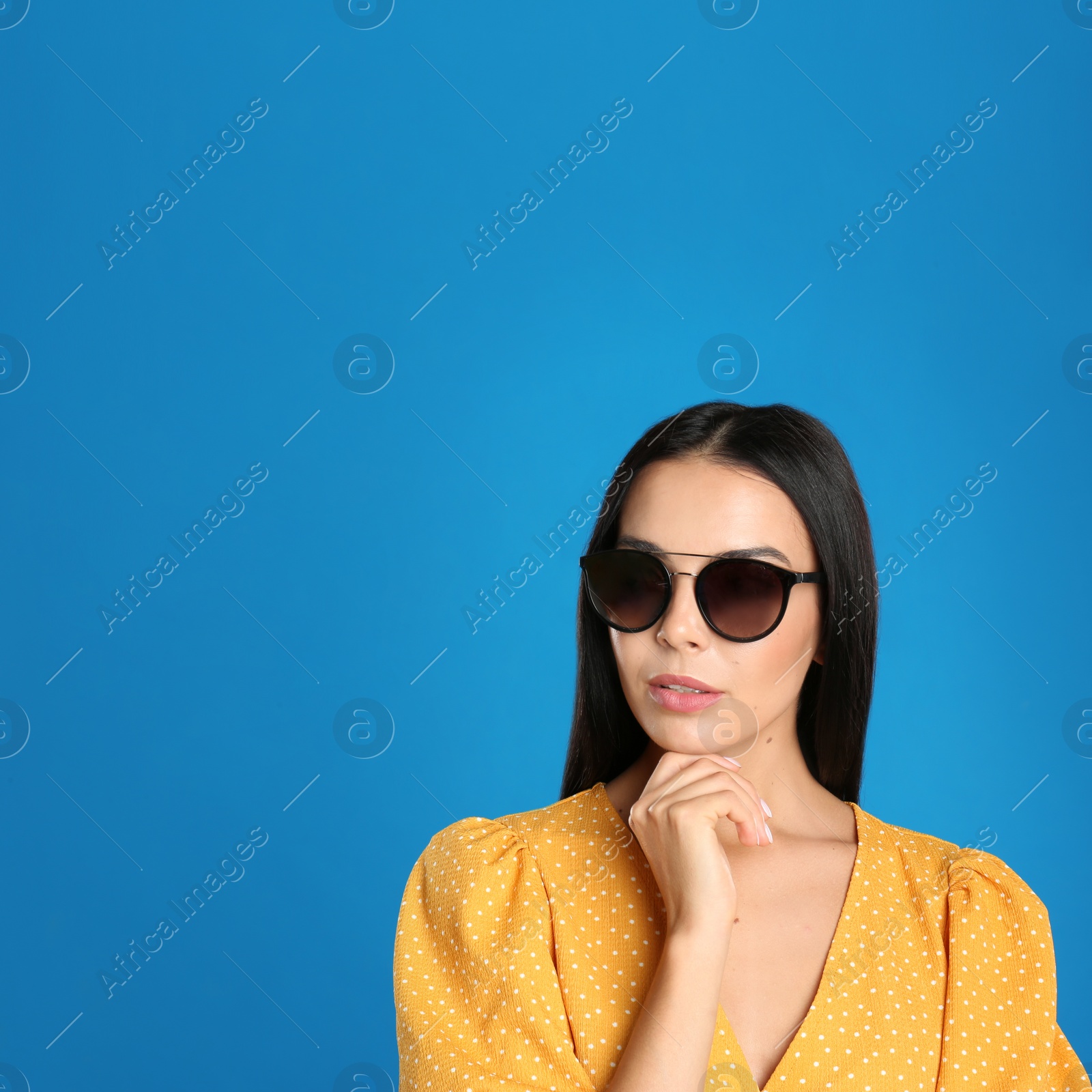 Photo of Beautiful woman wearing sunglasses on blue background. Space for text