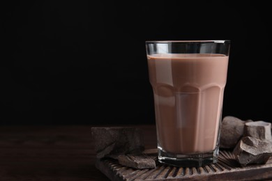 Fresh yummy chocolate milk on wooden table. Space for text