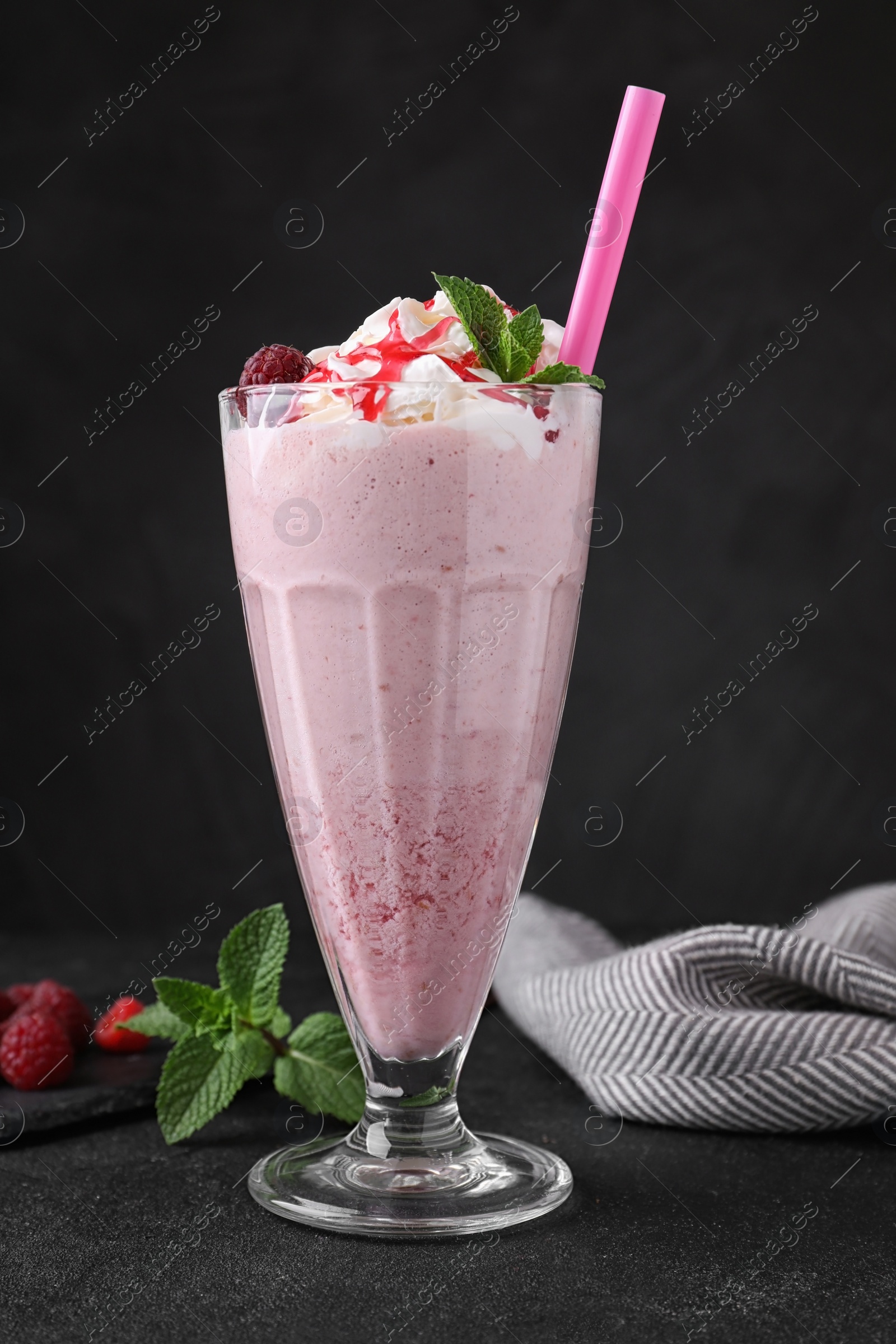 Photo of Tasty fresh milk shake in glass on black table