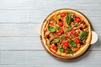 Tasty homemade pizza and space for text on wooden table, top view