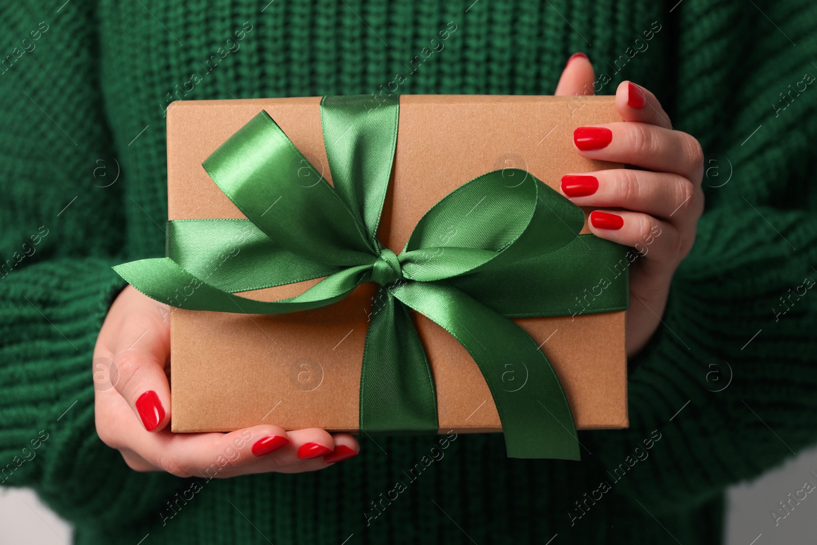 Photo of Christmas present. Woman holding gift box, closeup