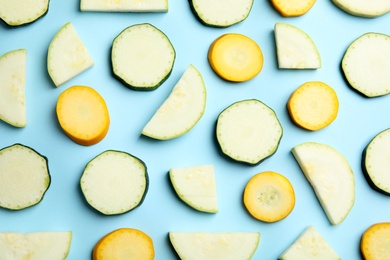 Photo of Fresh ripe cut zucchinis on light blue background, flat lay