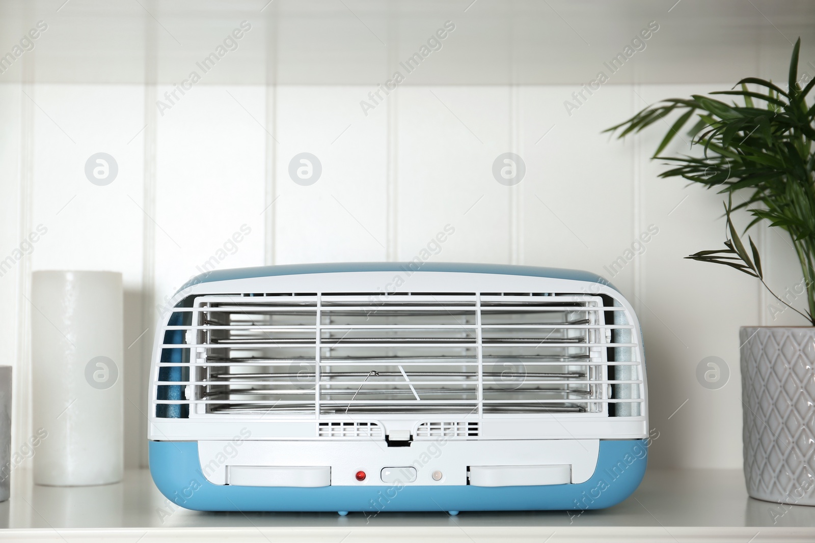 Photo of Modern air purifier on white wooden shelf