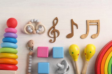 Photo of Baby song concept. Wooden notes, kids maracas and toys on table, flat lay