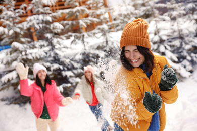 Group of friends playing snowballs outdoors. Winter vacation