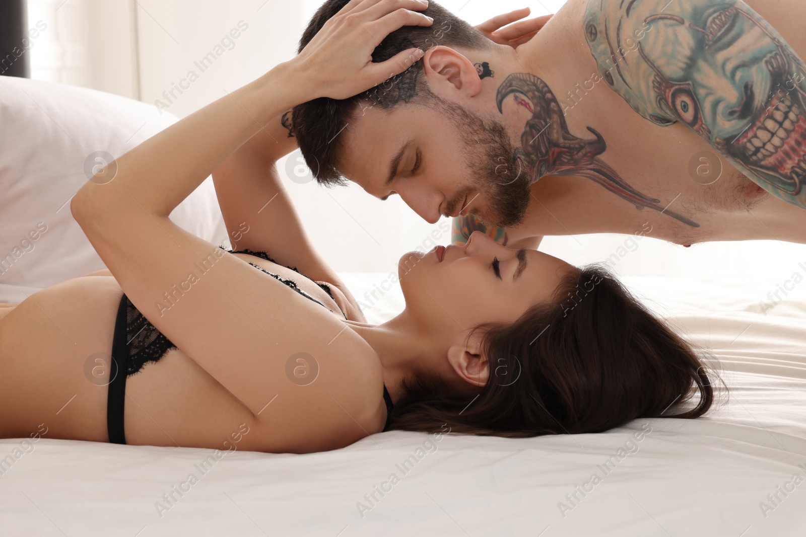 Photo of Passionate couple having sex on bed at home