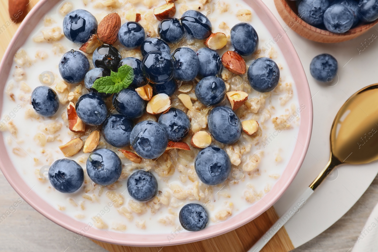 Photo of Flat lay composition with tasty oatmeal porridge and ingredients served on wooden table. Healthy meal