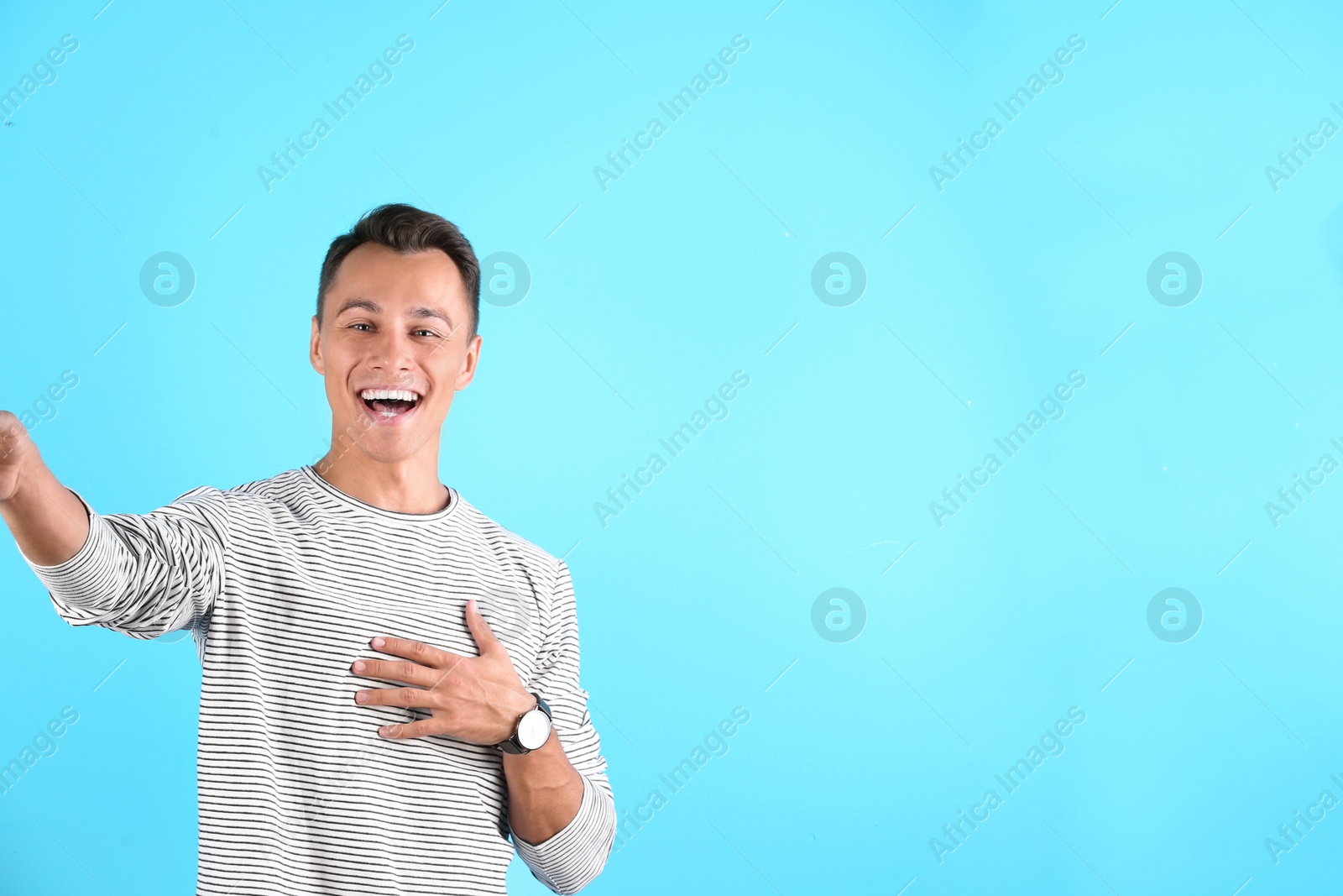 Photo of Laughing man taking selfie on color background. Space for text