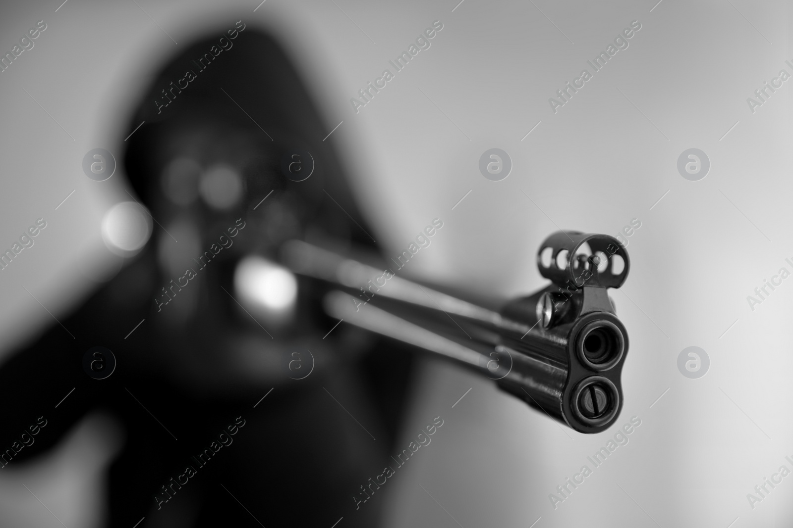 Photo of Hired professional killer indoors, focus on sniper rifle