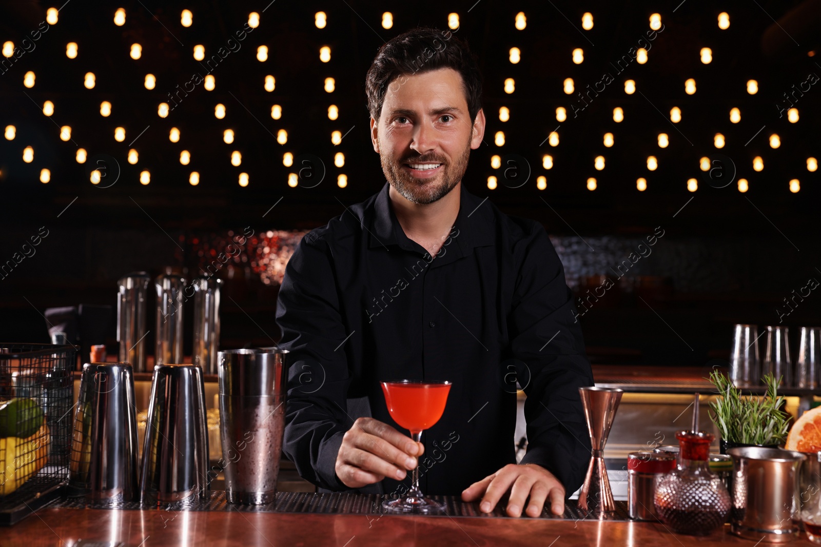 Photo of Bartender with fresh alcoholic cocktail in bar