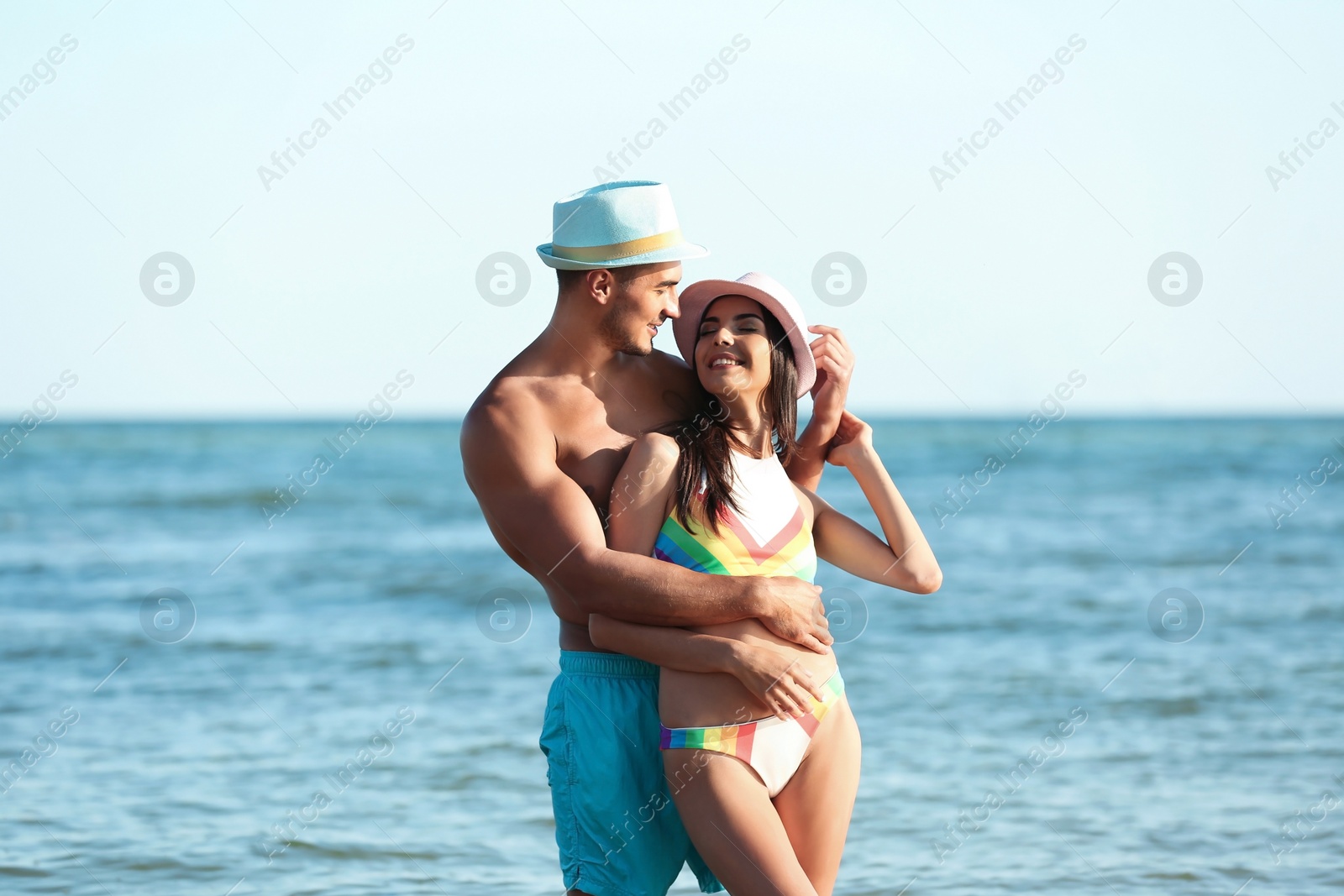 Photo of Happy young couple posing near sea on beach