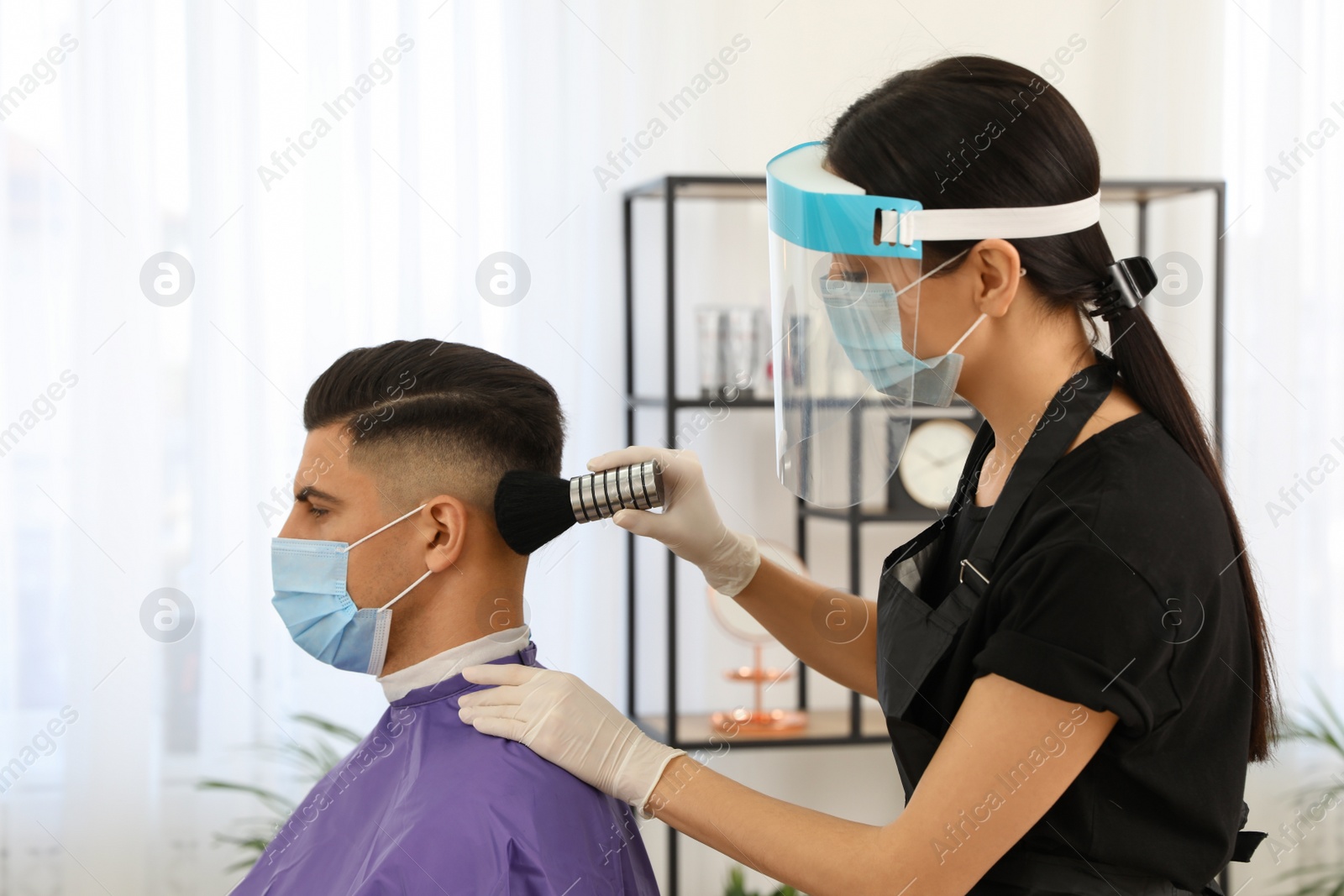 Photo of Professional stylist working with client in salon. Hairdressing services during Coronavirus quarantine