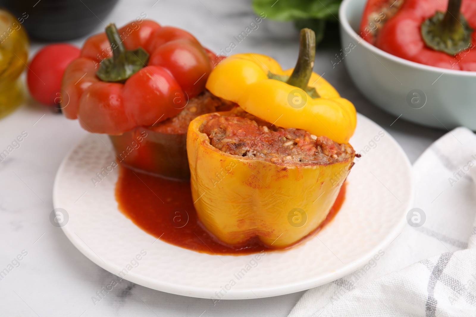 Photo of Delicious stuffed bell peppers served on white marble table