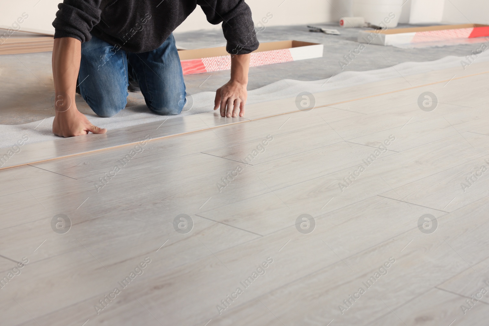 Photo of Professional worker installing new laminate flooring indoors