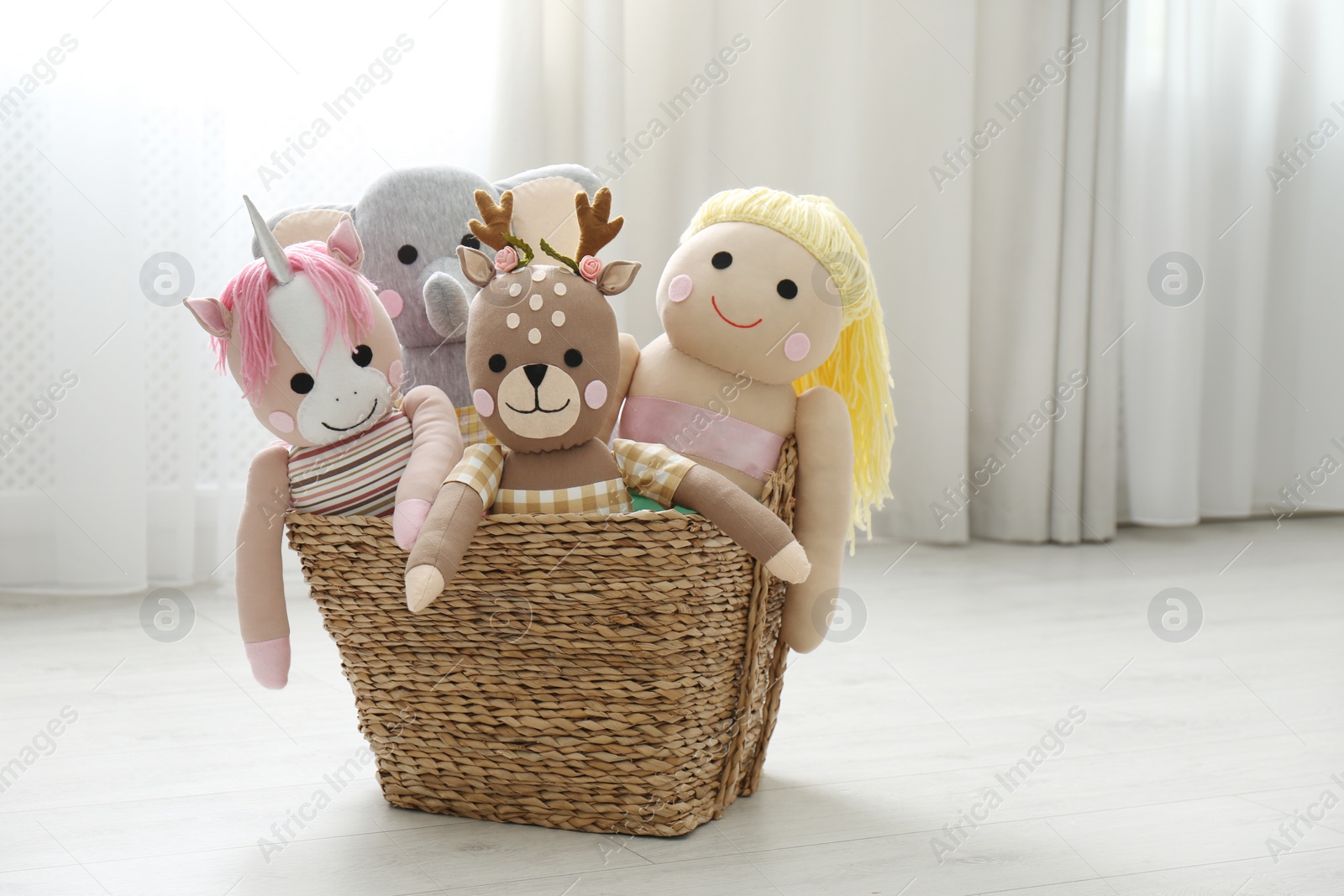 Photo of Funny toys in basket on floor. Decor for children's room interior
