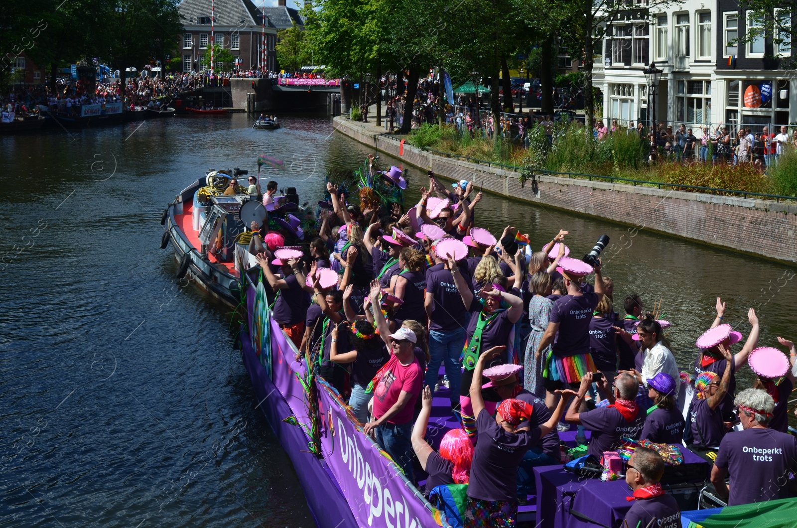 Photo of AMSTERDAM, NETHERLANDS - AUGUST 06, 2022: Many people in boats at LGBT pride parade on river