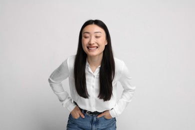 Portrait of smiling woman on light background