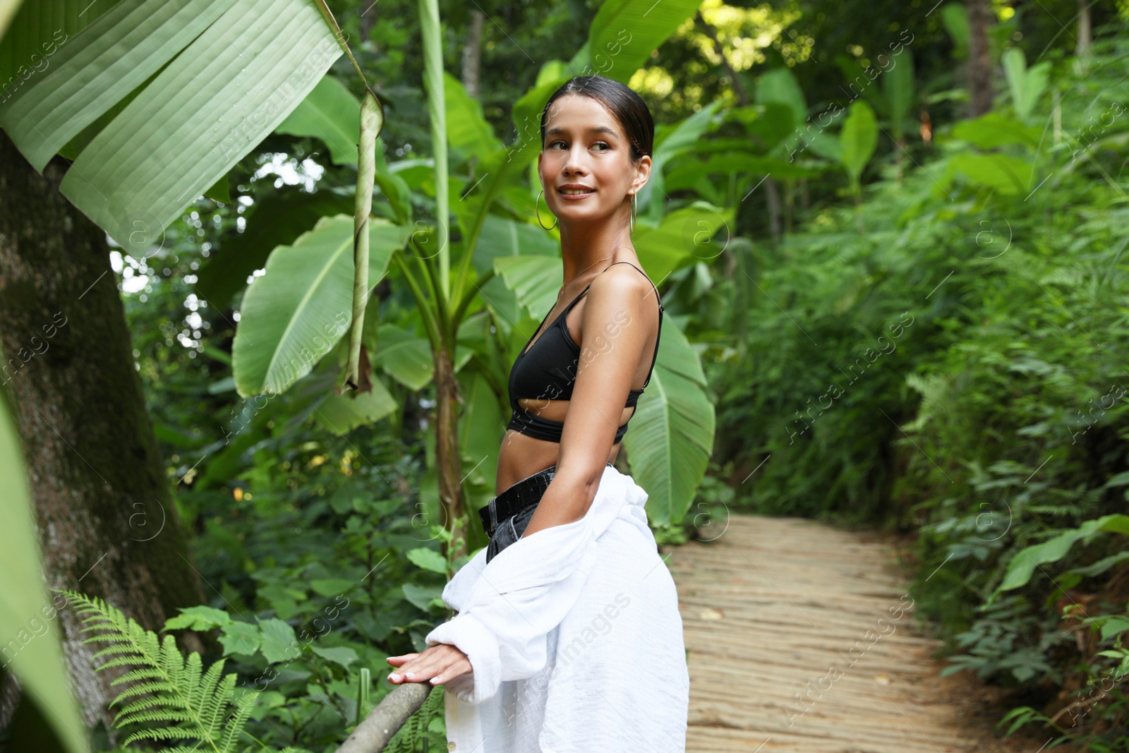 Photo of Beautiful young woman in green tropical park