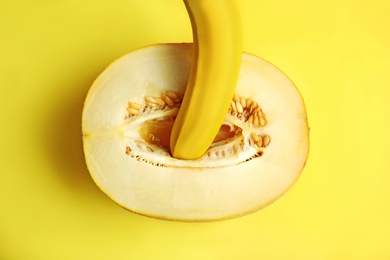 Photo of Flat lay composition with fresh banana and melon on yellow background. Sex concept