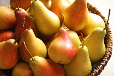 Wicker bowl with ripe pears, closeup. Healthy snack