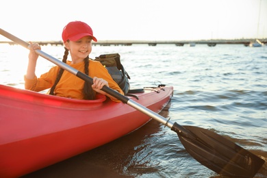 Happy girl kayaking on river. Summer camp activity