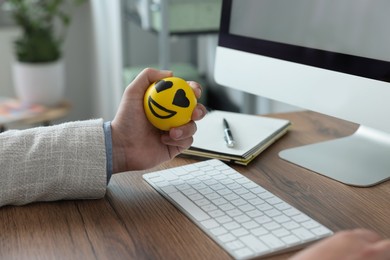Photo of Man with antistress ball at desk in office, closeup