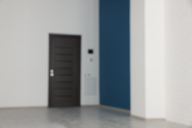 Photo of Blurred view of empty office room with color walls and black door. Interior design