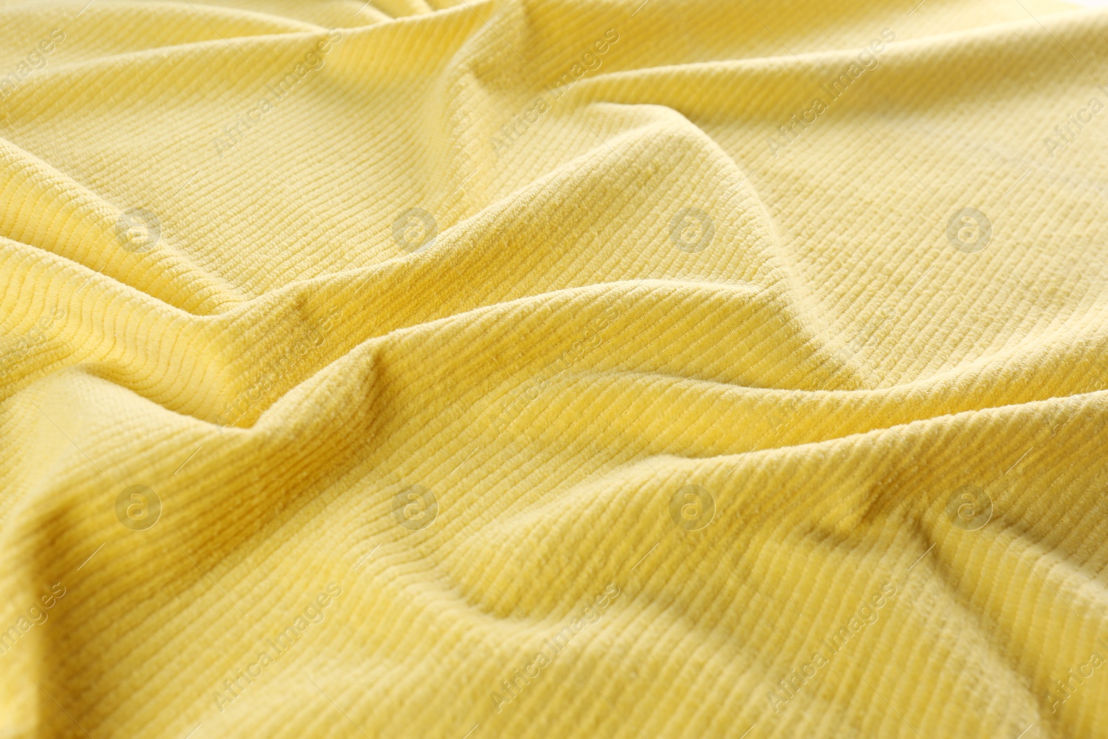 Photo of Crumpled yellow beach towel as background, closeup