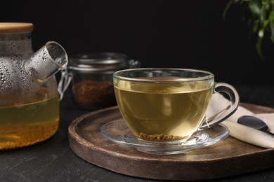 Photo of Freshly made buckwheat tea served on grey table