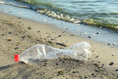 Photo of Used plastic bottle near water at beach. Environment pollution