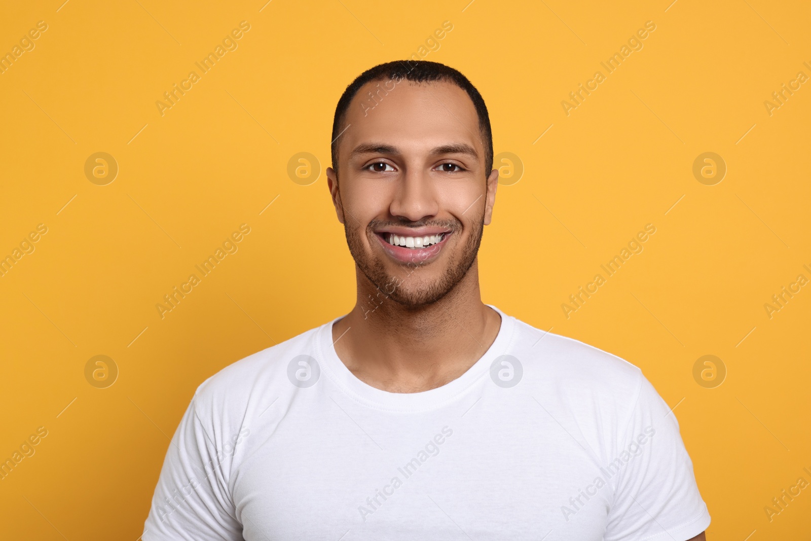 Photo of Portrait of happy African American man on orange background