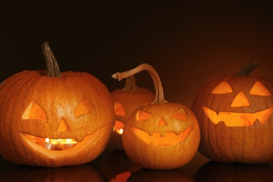 Halloween pumpkin heads. Glowing jack lanterns on dark background