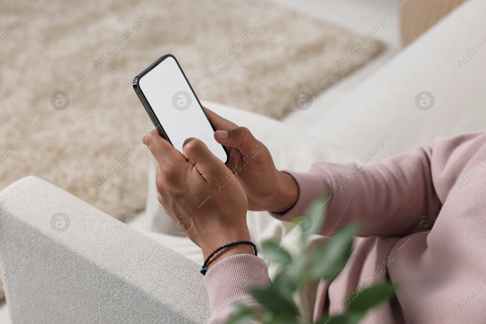 Photo of Man using modern mobile phone indoors, closeup