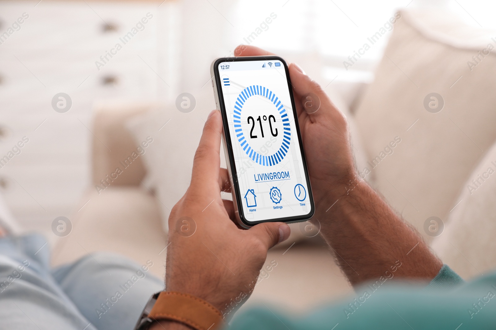 Image of Man using smartphone to control heating system in house, closeup