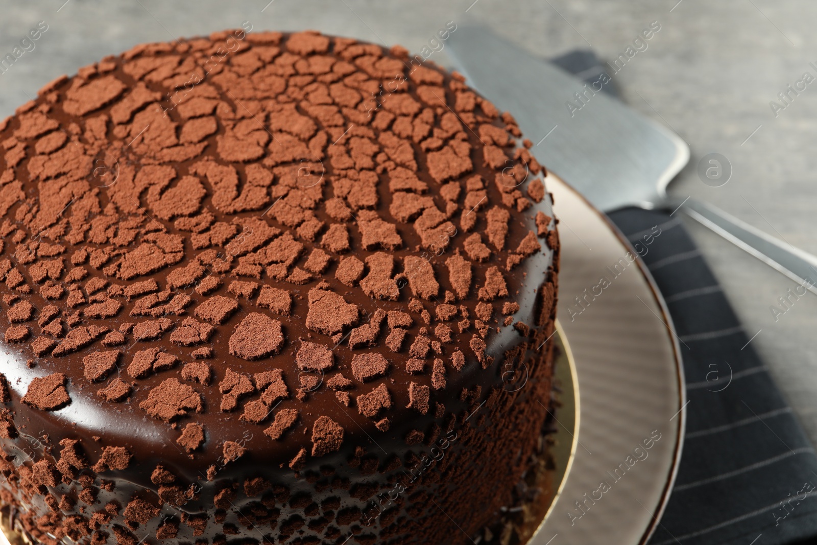 Photo of Delicious chocolate truffle cake and server on table, closeup