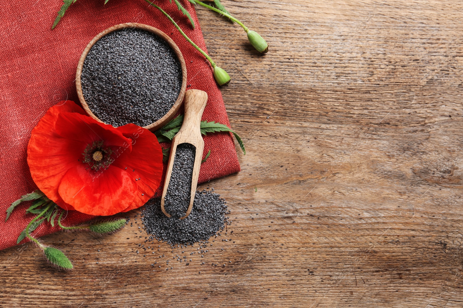 Photo of Flat lay composition with poppy seeds and flower on wooden table, space for text