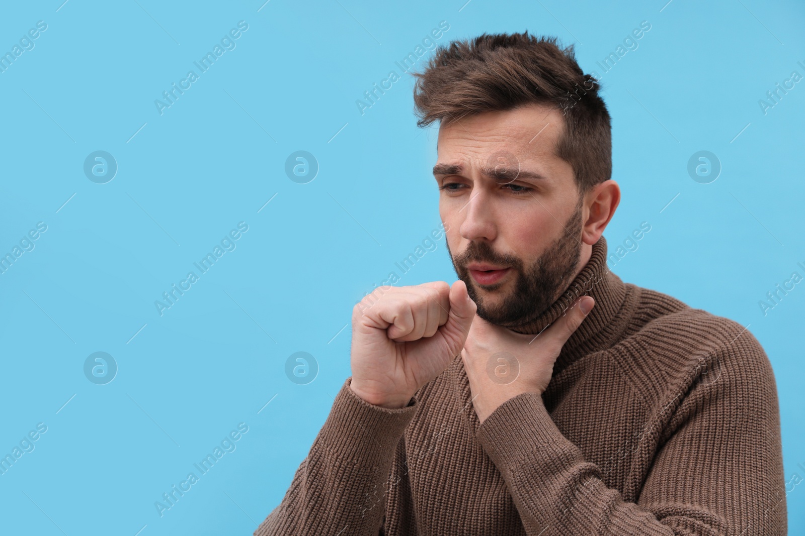 Photo of Man coughing on light blue background, space for text. Cold symptoms