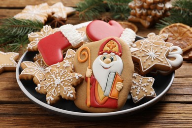 Photo of Tasty gingerbread cookies on wooden table, closeup. St. Nicholas Day celebration