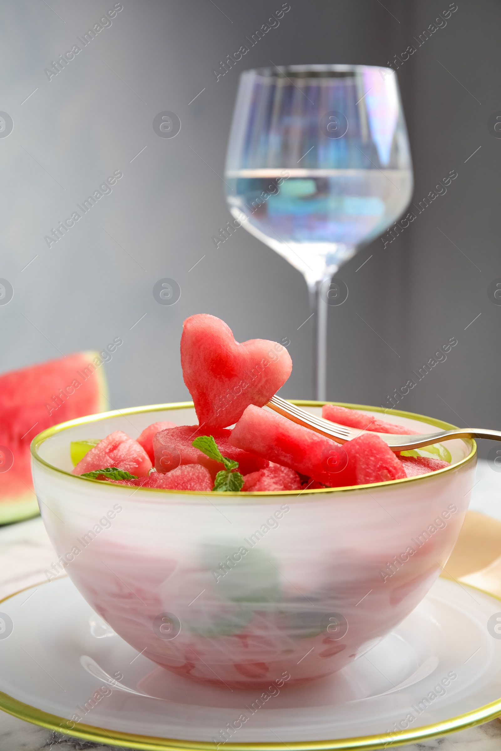 Photo of Delicious salad with watermelon on white marble table, closeup