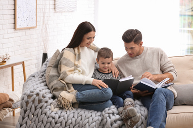 Happy family with little son reading books at home. Winter vacation