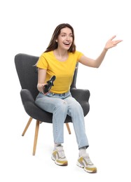 Photo of Happy woman with game controller sitting in armchair on white background