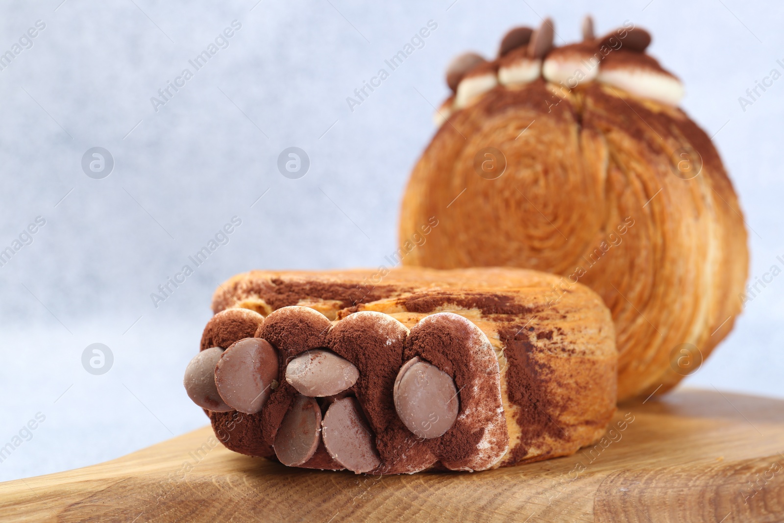 Photo of Supreme croissants with chocolate chips and cream on grey table, closeup. Tasty puff pastry