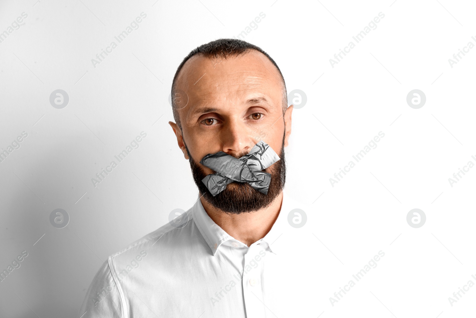 Image of Mature man with taped mouth on white background. Speech censorship