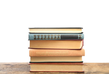 Stack of old vintage books on wooden table against white background