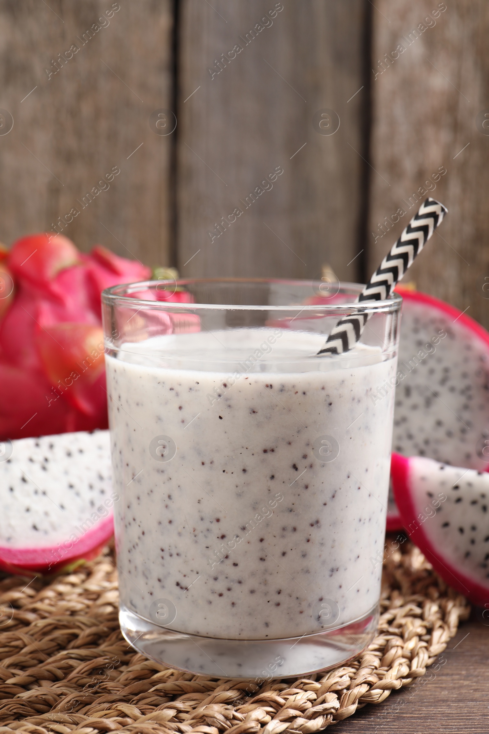 Photo of Delicious pitahaya smoothie and fresh fruits on wooden table